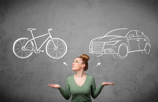 Mulher fazendo uma escolha entre bicicleta e carro — Fotografia de Stock