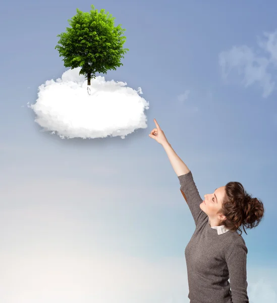 Niña apuntando a un árbol verde en la parte superior de una nube blanca — Foto de Stock