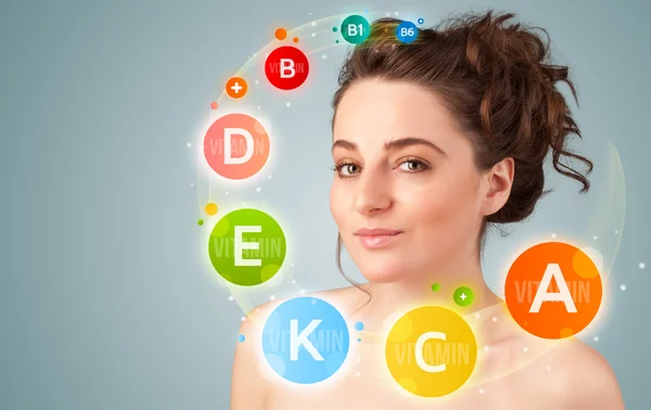 Menina bonita com ícones de vitaminas coloridas e símbolos — Fotografia de Stock