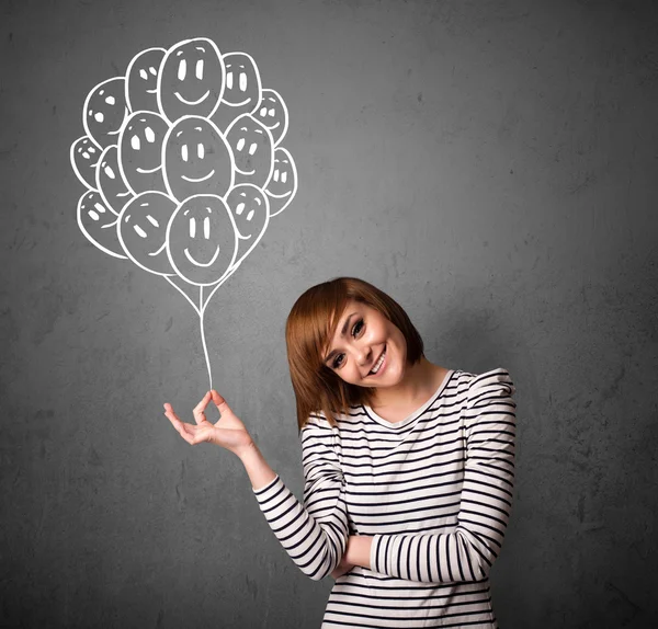 Mujer sosteniendo un montón de globos sonrientes —  Fotos de Stock