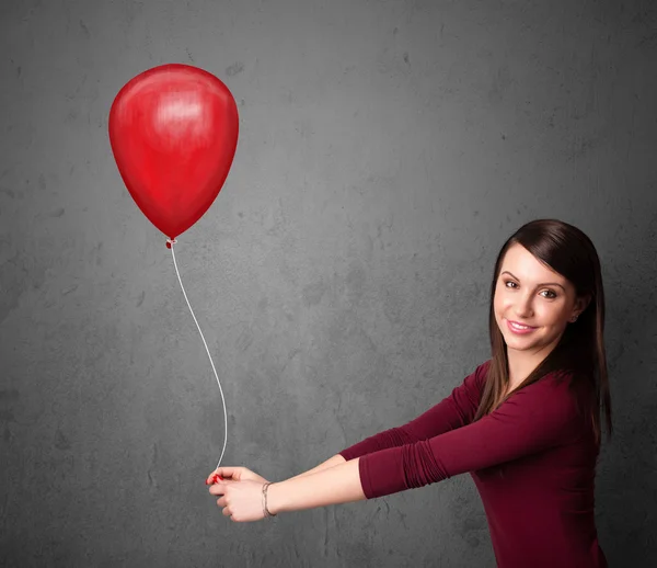 Femme tenant un ballon rouge — Photo