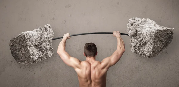 Hombre muscular levantando grandes pesos de piedra de roca —  Fotos de Stock