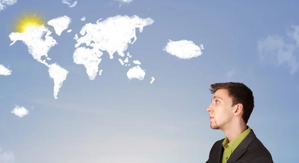 Businessman looking at world clouds and sun on blue sky — Stock Photo, Image