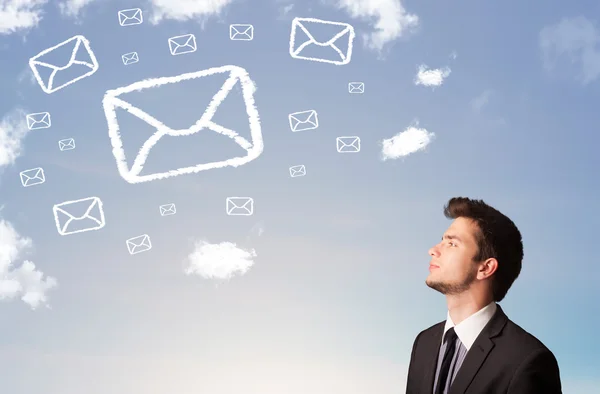 Podnikatel při pohledu na mail symbol mraky na obloze — Stock fotografie