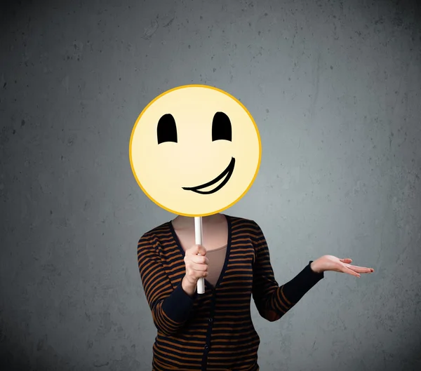 Jonge vrouw met een smiley gezicht emoticon — Stockfoto