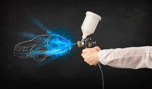 Worker with airbrush gun painting hand drawn car lines — Stock Photo, Image