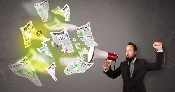 Guy yelling into loudspeaker and newspapers fly out — Stock Photo, Image