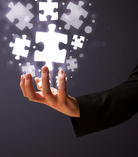 Puzzle pieces in the hand of a businessman — Stock Photo, Image