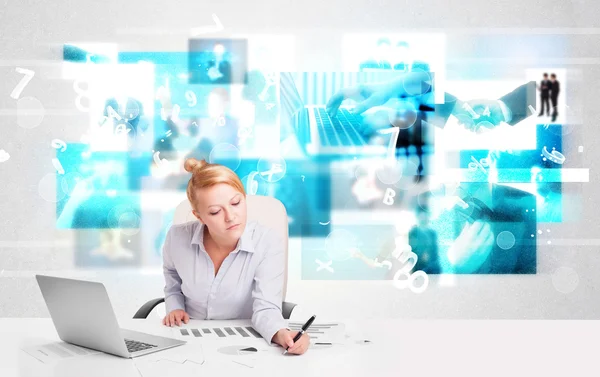 Business person at desk with modern tech images at background Stock Picture