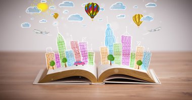 Açık kitap üzerine şehir manzarası çizimi