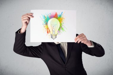boya sıçraması ve lightbul ile bir karton tutan işadamı