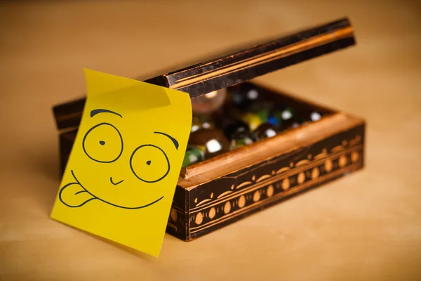 Nota post-it con la cara sonriente pegada en un joyero — Foto de Stock