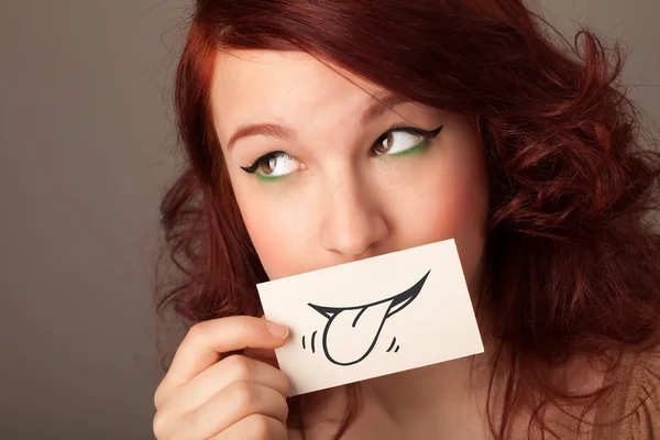 Pretty young girl holding white card with smile drawing — Stock Photo, Image