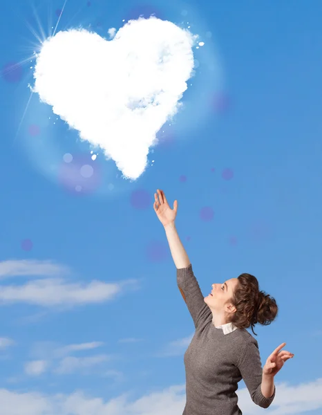 Niedliches Mädchen schaut auf weiße Herzwolken am blauen Himmel — Stockfoto