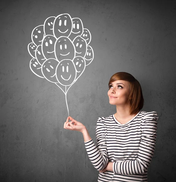 Woman holding a bunch of smiling balloons — Stock Photo, Image