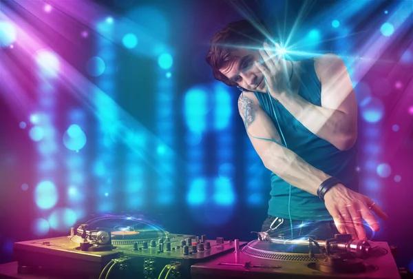 Dj misturando música em um clube com luzes azuis e roxas — Fotografia de Stock