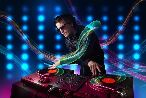 Young Dj mixing records with colorful lights — Stock Photo, Image