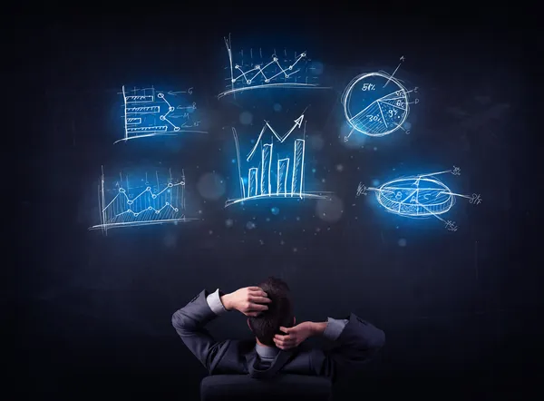 Businessman in chair looking at charts — Stock Photo, Image