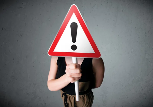 Young woman holding an exclamation road sign — Stock Photo, Image
