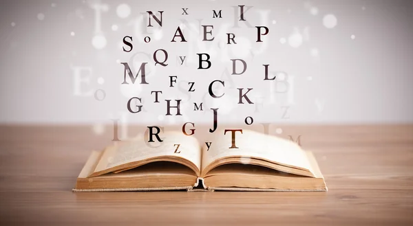 Livre ouvert avec lettres volantes — Photo