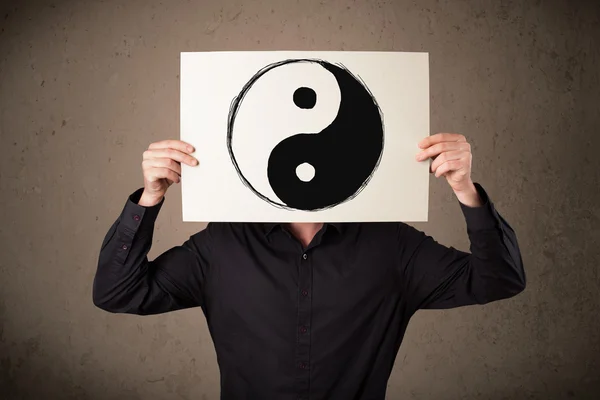 Omul de afaceri deține o hârtie cu un yin-yang pe ea în fața hi — Fotografie, imagine de stoc