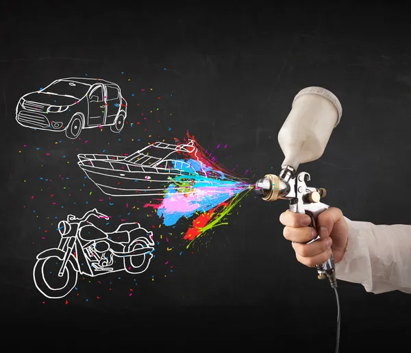 Człowiek z farby w sprayu airbrush z samochodu, łodzi i motocykl narysować — Zdjęcie stockowe