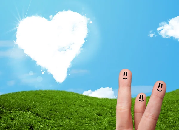 Happy smiley fingers looking at heart shaped cloud — Stock Photo, Image