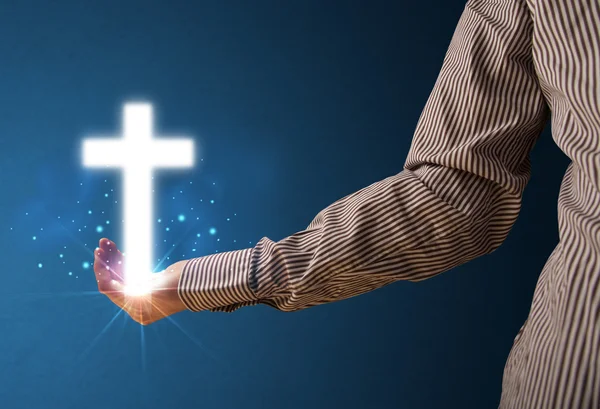 Glowing cross in the hand of a businessman — Stock Photo, Image