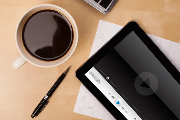 Tablet pc üzerinde medya oynatıcı bir fincan kahve ile ekranda gösterilen Telifsiz Stok Imajlar