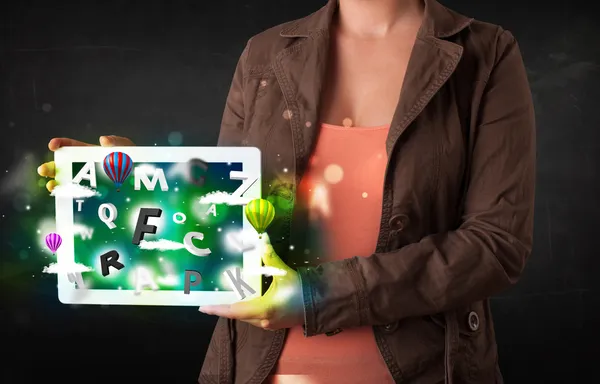 Joven mostrando tableta con letras abstractas y cielo — Foto de Stock
