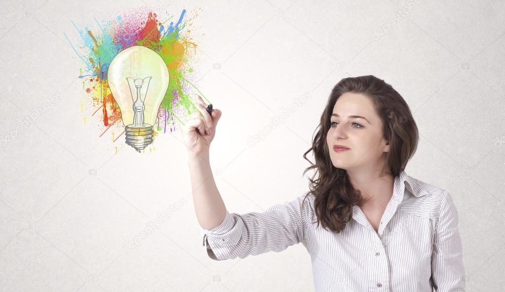 Young lady drawing a colorful light bulb with colorful splashes