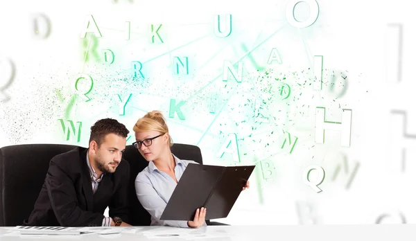 Business people at desk with green word cloud — Stock Photo, Image