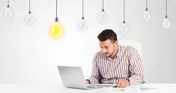 Hombre de negocios sentado en la mesa con bombillas idea — Foto de Stock