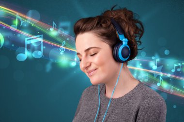 Kulaklıkla müzik dinleyen genç bir kadın.
