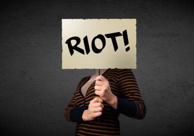 bir protesto işaret tutan genç kadın