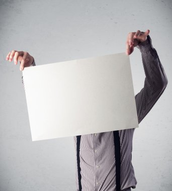 İşadamı elinde fotokopi alanı olan bir kağıt tutuyor.