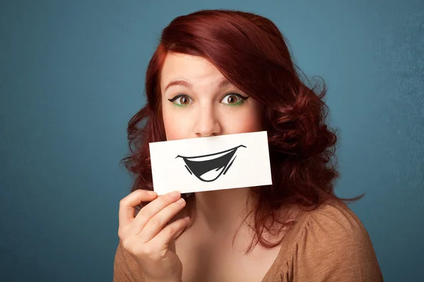 Felice ragazza carina in possesso di carta con divertente disegno smiley — Foto Stock