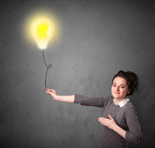 Woman holding a lightbulb balloon — Stock Photo, Image