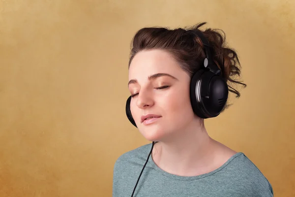 Young woman with headphones listening to music with copy space — Stock Photo, Image