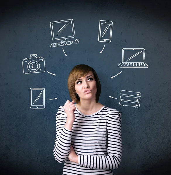 Jeune femme pensant avec des gadgets dessinés autour de sa tête — Photo