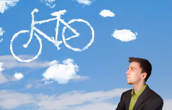 Young man looking at bicycle clouds on blue sky — Stock Photo, Image