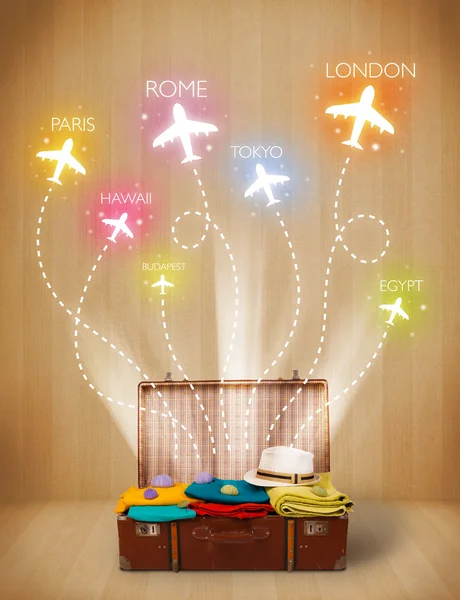 Cestovní tašku s oblečením a barevné letadla létají z — Stock fotografie