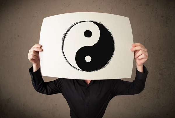 Homme d'affaires tenant un papier avec un yin-yang dessus en face de salut — Photo