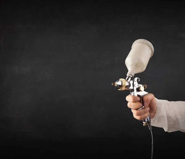 Pintor trabalha com pistola de aerógrafo e espaço livre vazio — Fotografia de Stock