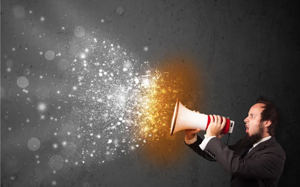 Guy shouting into megaphone and glowing energy particles explode — Stock Photo, Image