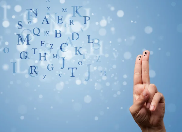Happy smiley fingers looking at mixture of bokeh letters — Stock Photo, Image
