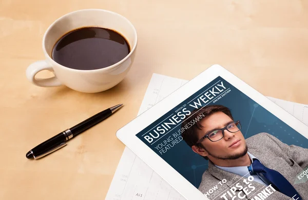 Tablet pc showing magazine on screen with a cup of coffee on a d — Stock Photo, Image