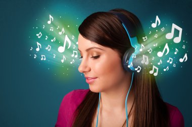 Kulaklıklı genç bir kadın müzik dinliyor.