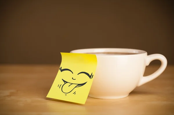 Nota post-it con la cara sonriente pegada en la taza — Foto de Stock