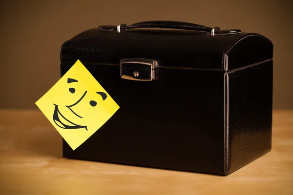 Post-it note with smiley face sticked on a box — Stock Photo, Image
